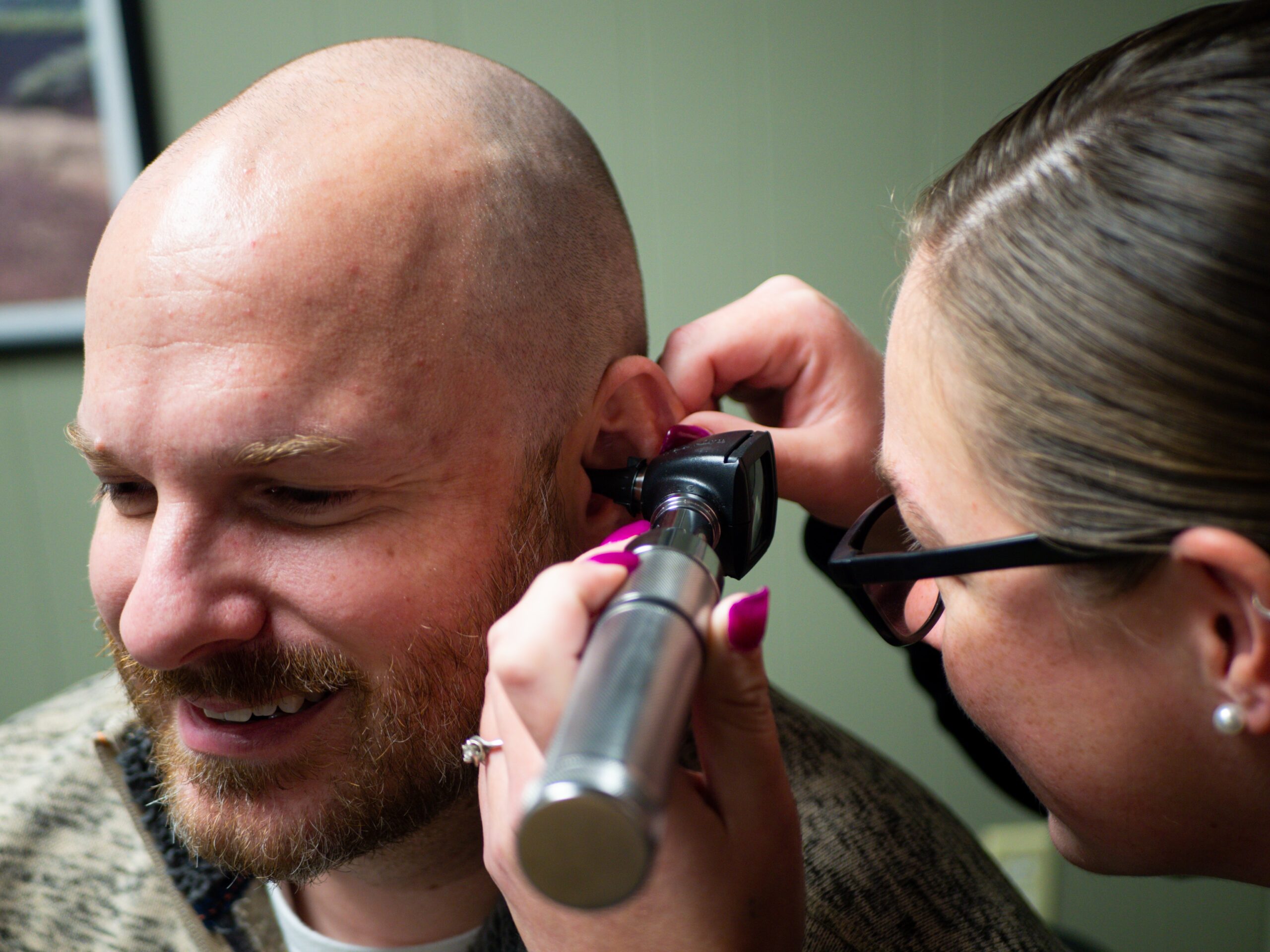 Akustičarka proverava da li su ušni kanali pacijenta čisti da bi bezbedno obavila audiometriju