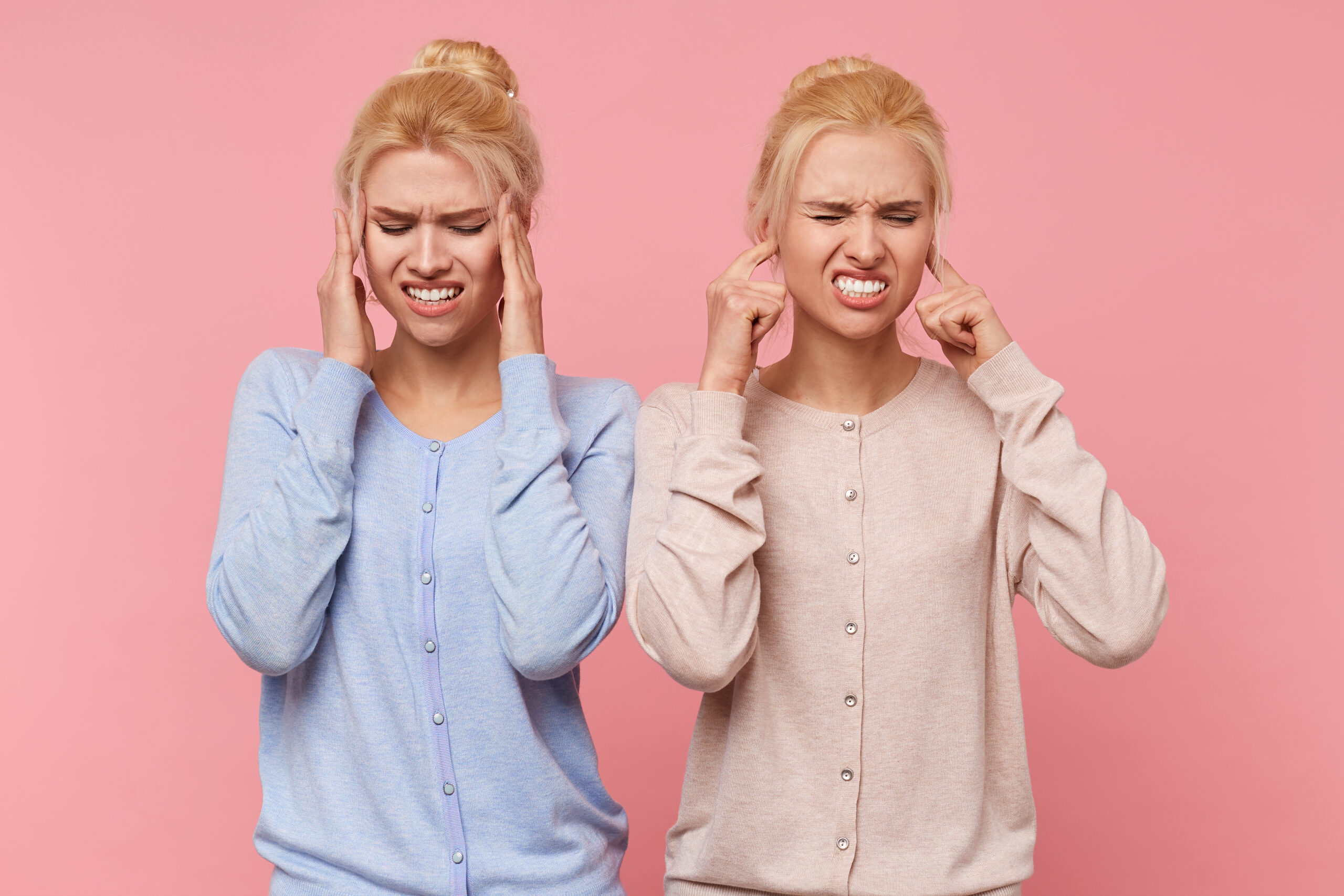 Slika dve devojke sa tinitusom koje se drže za uši