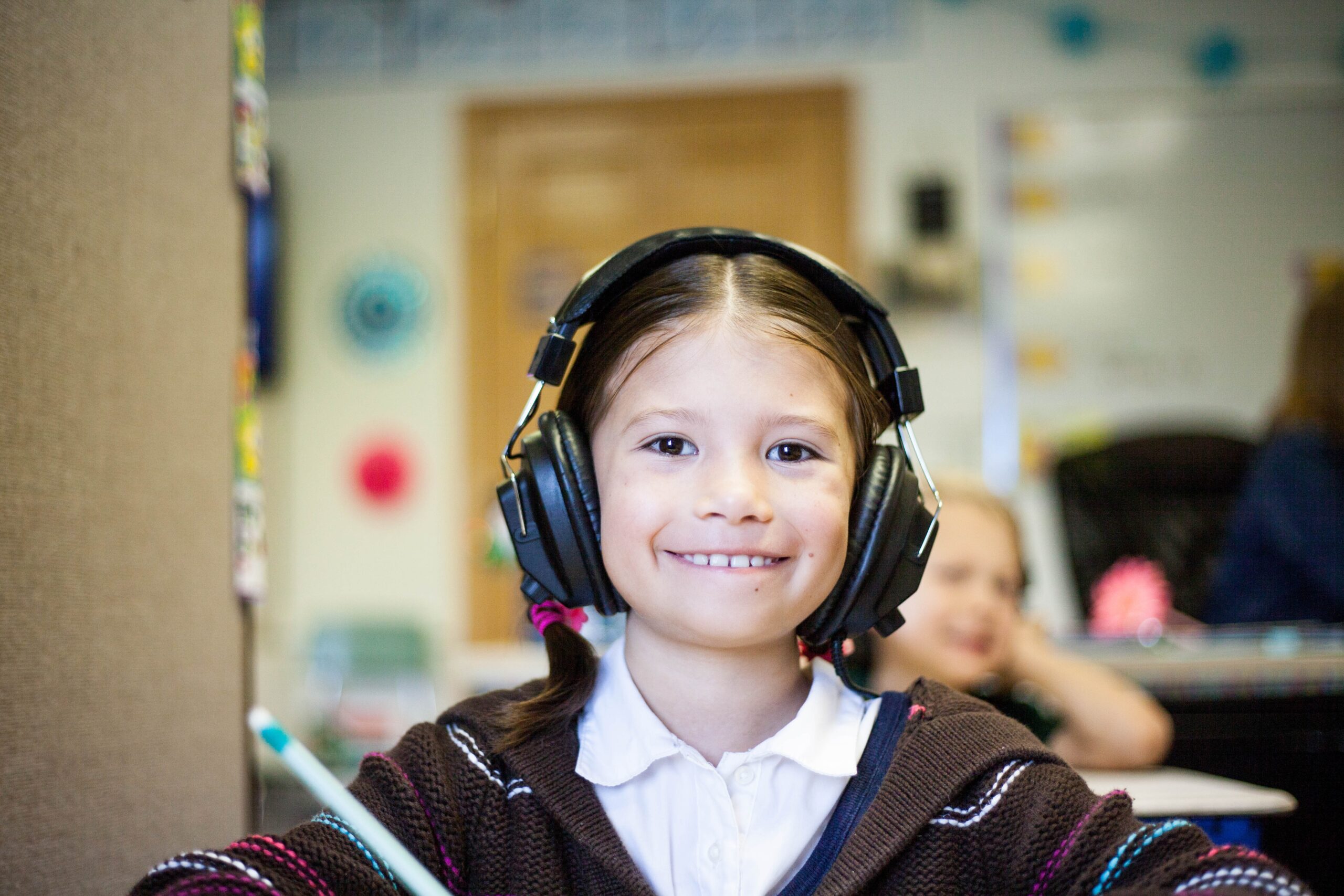 nasmejano dete sa slušalicama u ušima na testiranju sluha