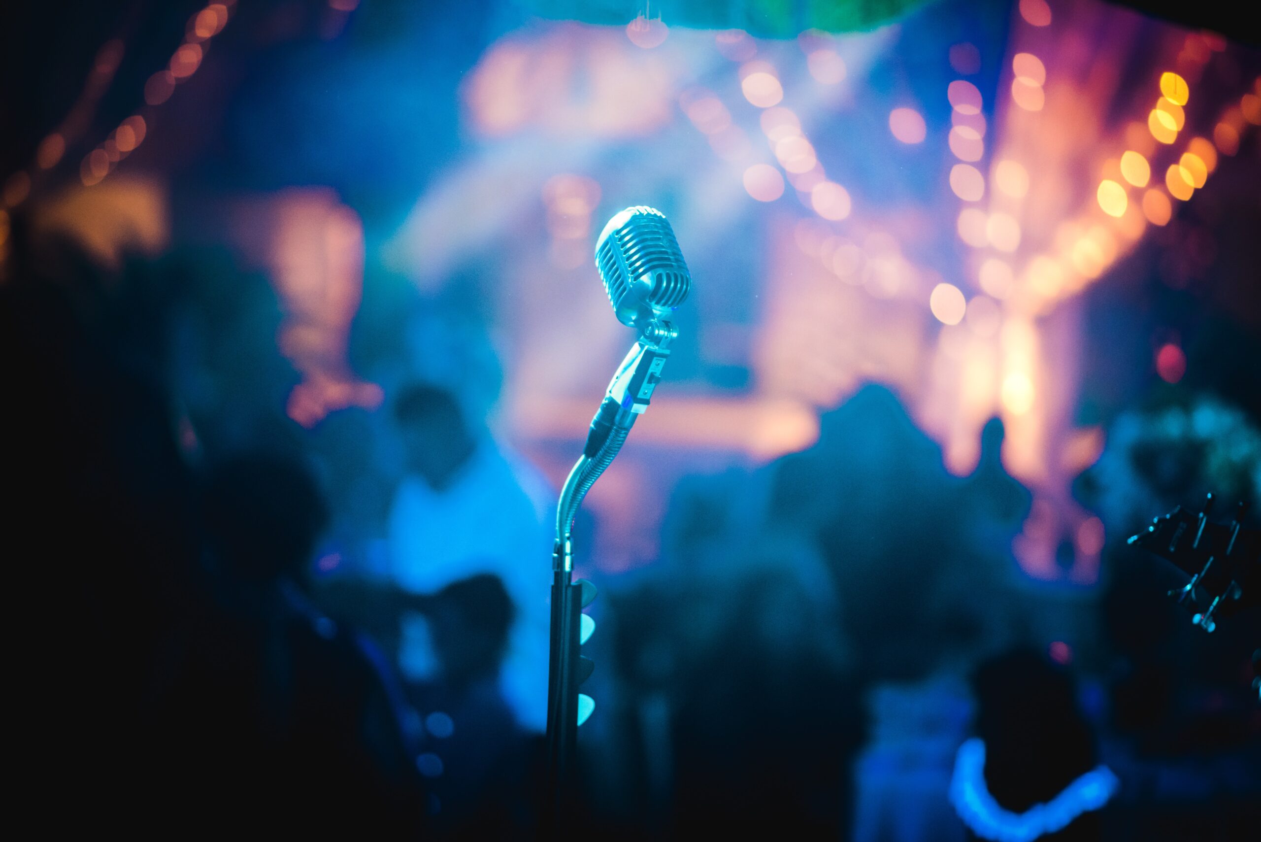 Slika mikrofona i nocnog svetla u pozadini, kao na nekom koncertu ili na svirci