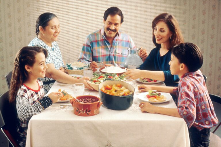 porodica razgovara za stolom dok jedu
